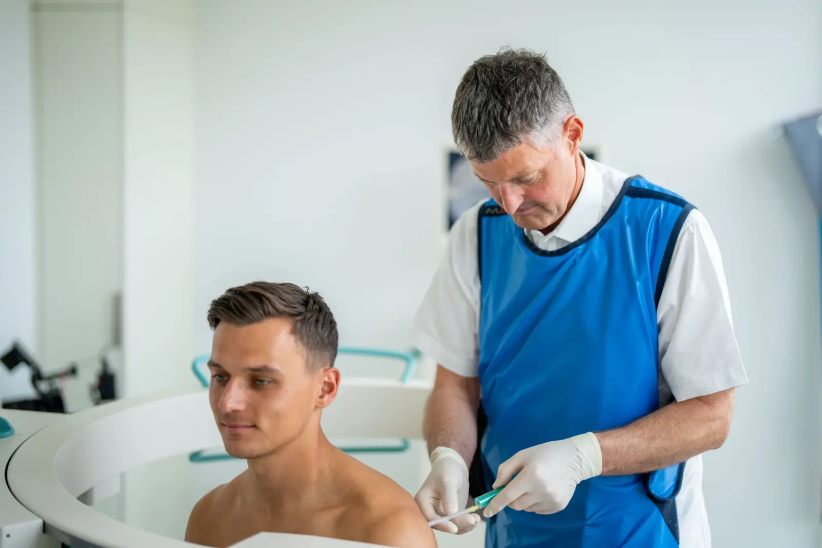 Dr. Knut Bär bereitet mit Röntgenschürze eine Injektion vor